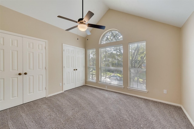 unfurnished bedroom with multiple closets, ceiling fan, lofted ceiling, and carpet