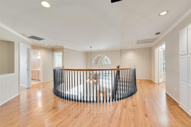 corridor featuring ornamental molding, light hardwood / wood-style flooring, and plenty of natural light