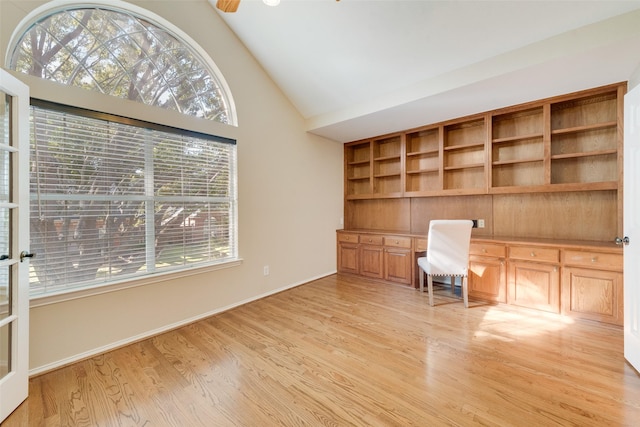 unfurnished office with light wood-type flooring, ceiling fan, and vaulted ceiling