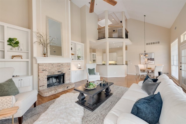 living room featuring high vaulted ceiling, a fireplace, ceiling fan, and hardwood / wood-style flooring