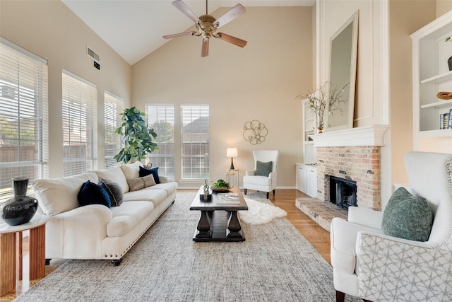 living room featuring lofted ceiling, hardwood / wood-style flooring, ceiling fan, and a fireplace