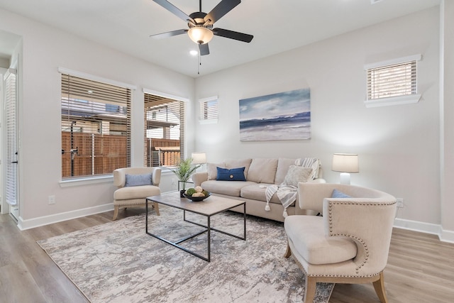 living room with ceiling fan and light hardwood / wood-style flooring