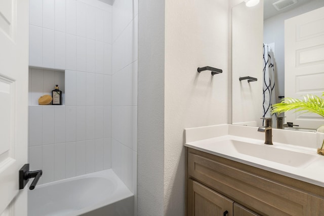 bathroom featuring vanity and tiled shower / bath combo