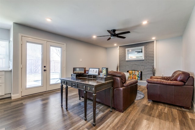 living room with ceiling fan, dark hardwood / wood-style flooring, french doors, and a brick fireplace