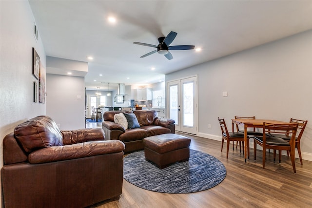 living room with ceiling fan, french doors, hardwood / wood-style floors, and sink