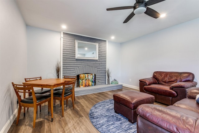 living room featuring hardwood / wood-style floors, a fireplace, and ceiling fan