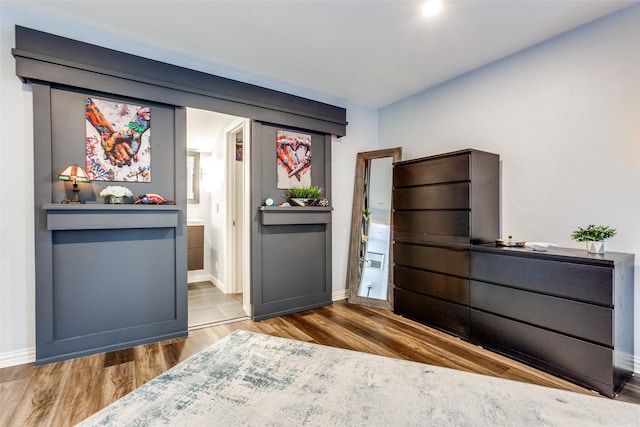 unfurnished bedroom featuring connected bathroom and hardwood / wood-style floors