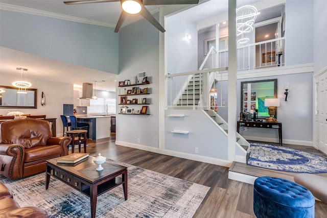 living room with ornamental molding, ceiling fan, a high ceiling, and hardwood / wood-style flooring