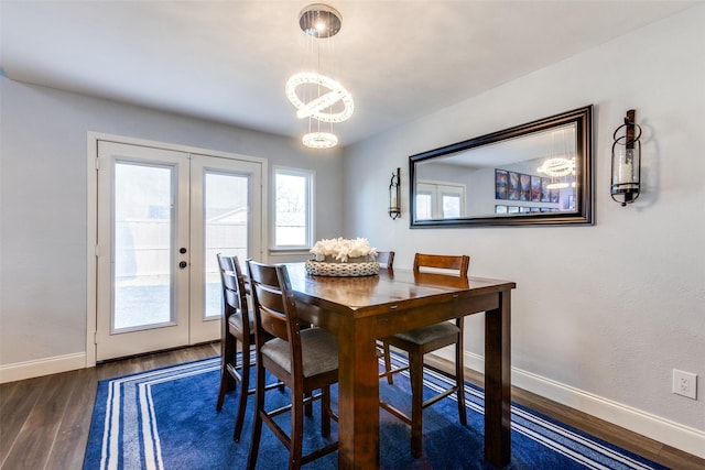 dining area with french doors, dark hardwood / wood-style flooring, and a notable chandelier