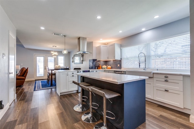 kitchen featuring white cabinets, hanging light fixtures, a center island, and extractor fan