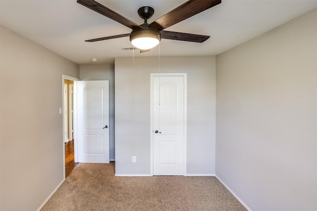 unfurnished bedroom with a ceiling fan, carpet flooring, visible vents, and baseboards