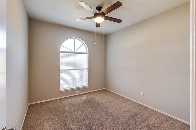 empty room with a wealth of natural light, baseboards, ceiling fan, and carpet