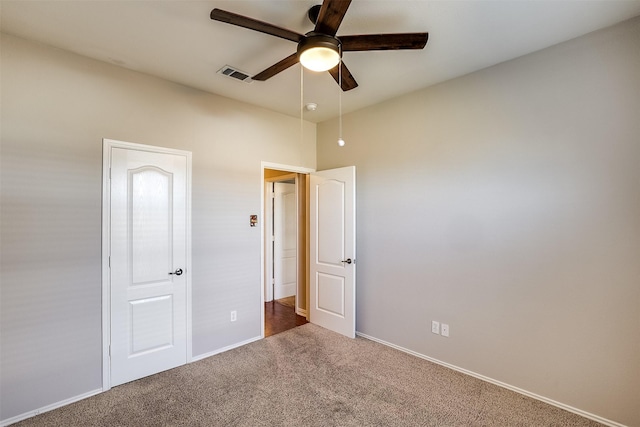 unfurnished bedroom with baseboards, carpet, visible vents, and a ceiling fan