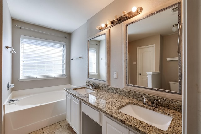 full bathroom featuring double vanity, tile patterned flooring, a sink, and a bath