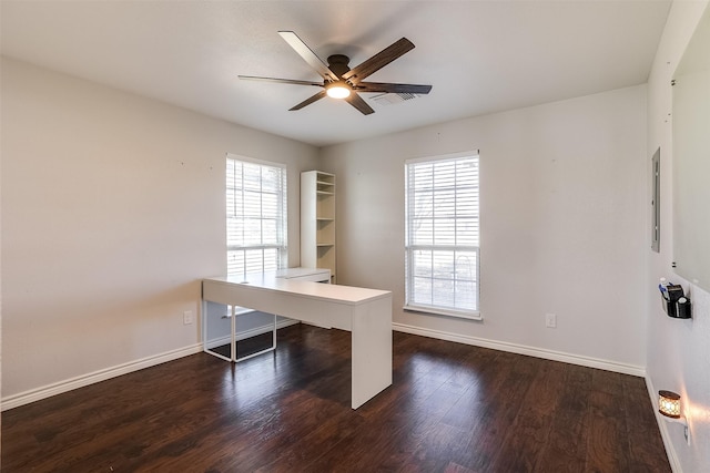 unfurnished office featuring dark wood-style floors, ceiling fan, and baseboards