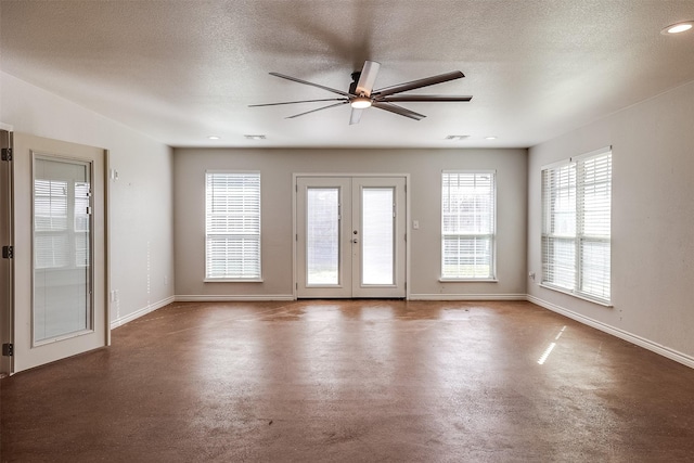 spare room featuring baseboards, a textured ceiling, and french doors