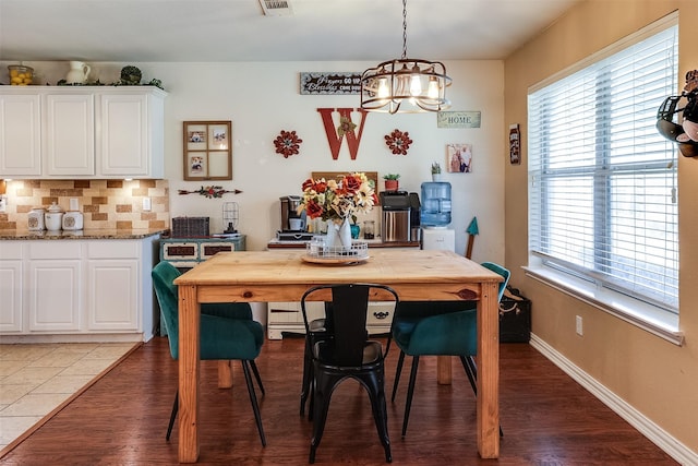 dining space featuring wood-type flooring and a notable chandelier