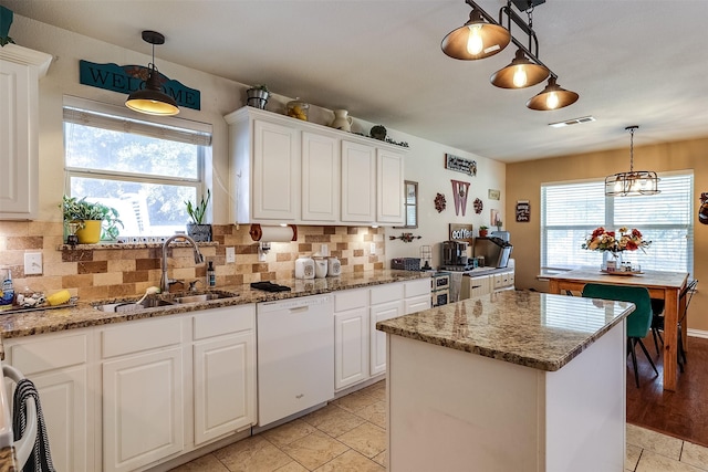 kitchen featuring a center island, white cabinetry, dishwasher, and decorative light fixtures