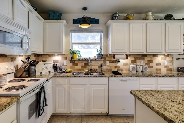 kitchen with sink, white appliances, light stone counters, and white cabinets