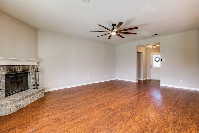 unfurnished living room featuring a fireplace, visible vents, ceiling fan, wood finished floors, and baseboards