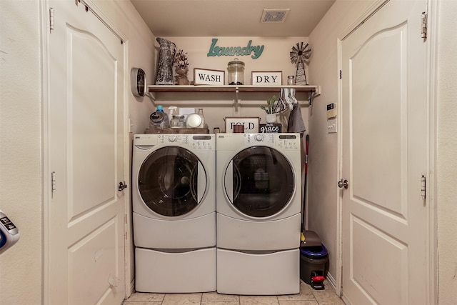 clothes washing area featuring washer and dryer and light tile patterned flooring