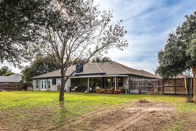 rear view of property featuring a yard