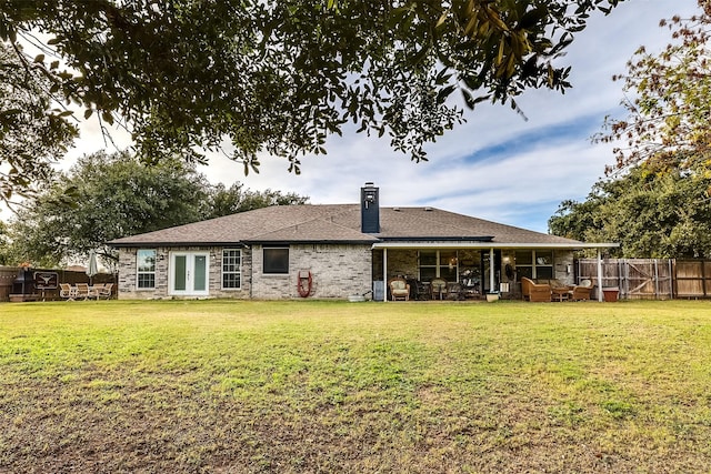 rear view of property with a lawn