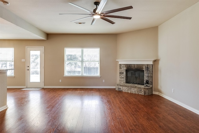 unfurnished living room with a fireplace, visible vents, ceiling fan, wood finished floors, and baseboards