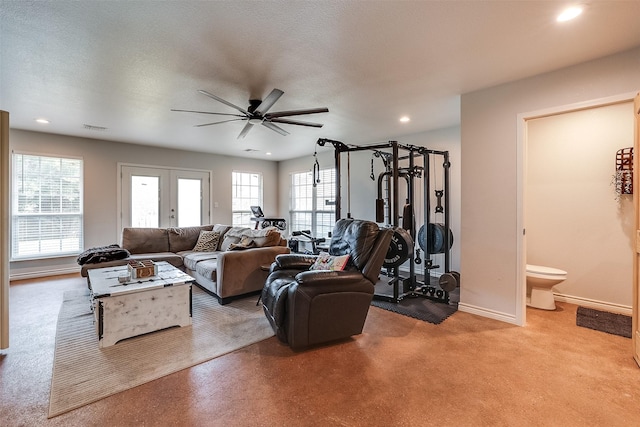 living room with ceiling fan, french doors, and a textured ceiling