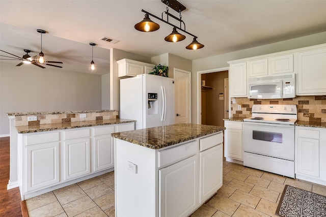 kitchen featuring tasteful backsplash, white appliances, white cabinets, and a kitchen island