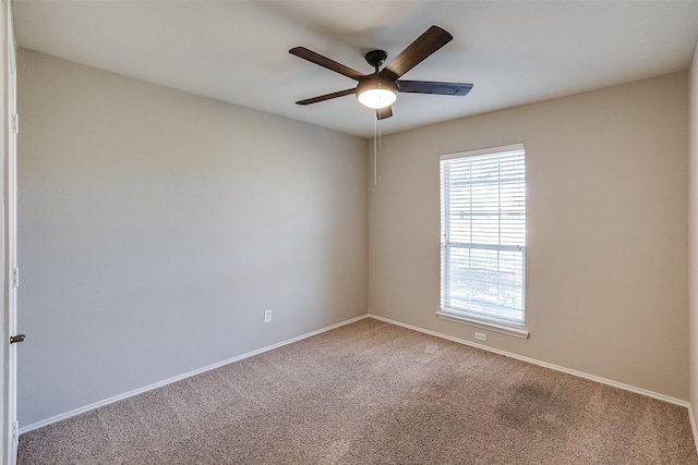 empty room featuring carpet, a ceiling fan, and baseboards