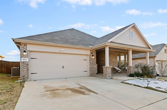 view of front facade with covered porch, central AC unit, and a garage