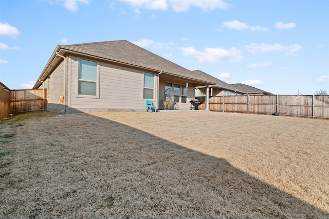 back of property with a patio and a yard