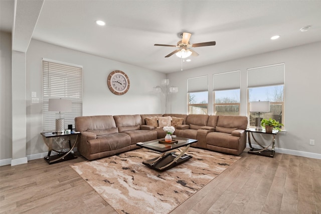 living room featuring ceiling fan and light hardwood / wood-style flooring