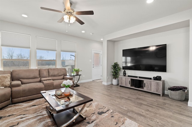 living room featuring light wood-type flooring and ceiling fan