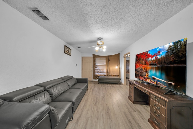 living room featuring a textured ceiling, ceiling fan, and light hardwood / wood-style flooring