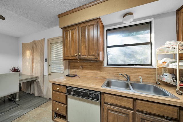 kitchen with sink, decorative backsplash, a textured ceiling, and dishwasher