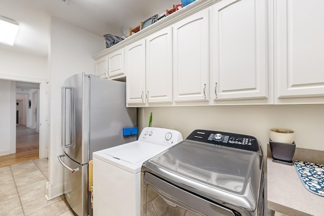 laundry room featuring light tile patterned flooring, cabinets, and washing machine and clothes dryer