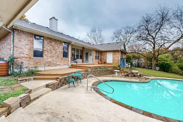 view of swimming pool featuring a patio area and a wooden deck