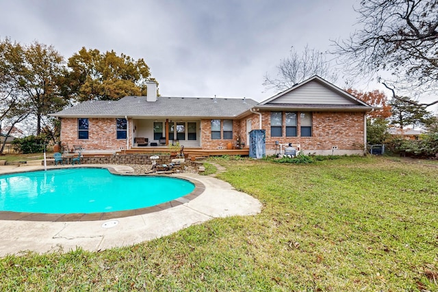 back of property with a lawn and a patio area