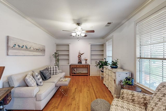 living room with light wood-type flooring, ceiling fan, and ornamental molding