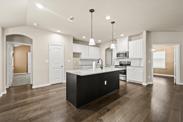 kitchen with stainless steel appliances, white cabinets, lofted ceiling, and a kitchen island with sink