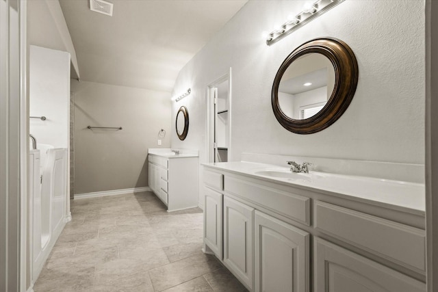 bathroom with lofted ceiling and vanity