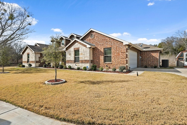 view of front of property with a front yard, central AC unit, and a garage