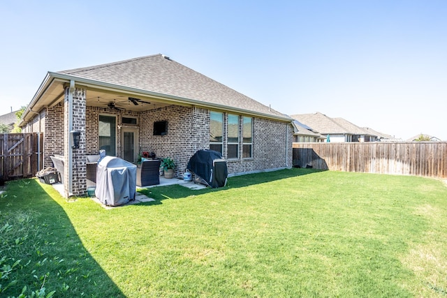 rear view of house featuring ceiling fan, a patio, and a lawn