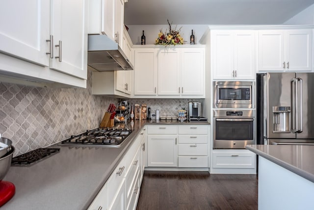 kitchen featuring appliances with stainless steel finishes, dark wood-type flooring, white cabinets, and backsplash