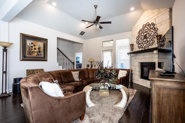 living room featuring a fireplace, ceiling fan, vaulted ceiling, and dark wood-type flooring