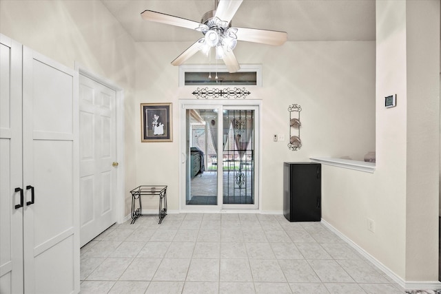 foyer entrance with ceiling fan and light tile patterned floors