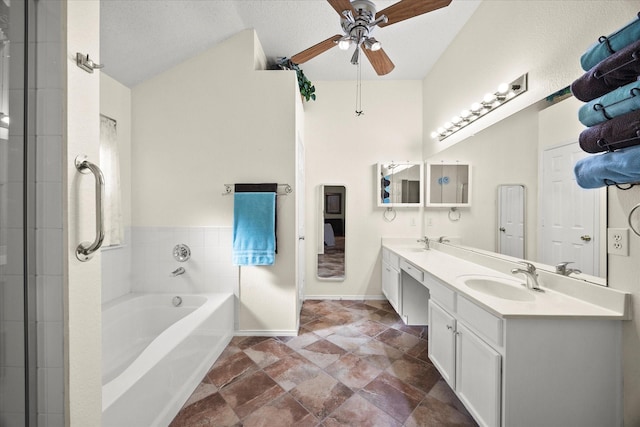 bathroom with a textured ceiling, ceiling fan, vanity, and a bathing tub