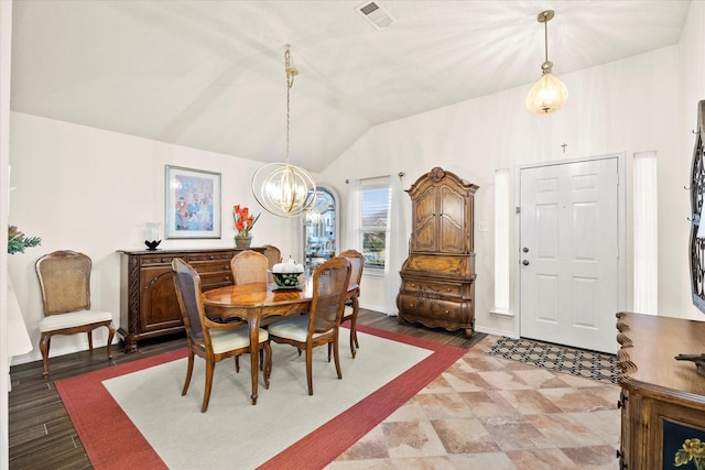 dining room with a chandelier and vaulted ceiling